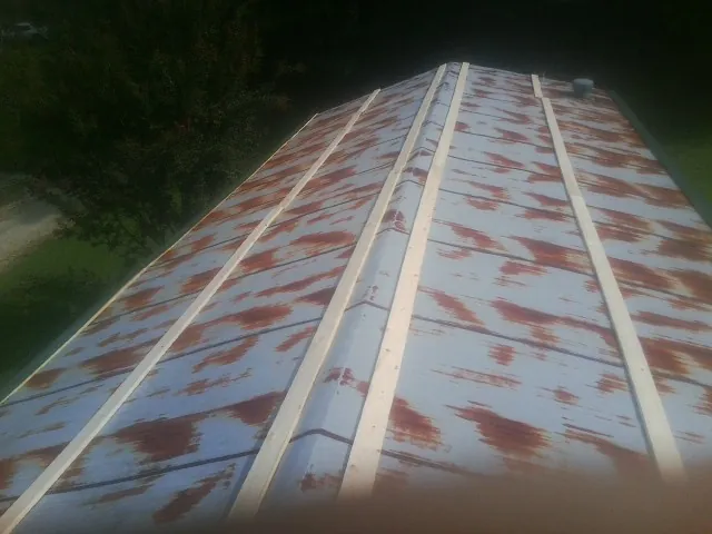Rusted metal roof panels with new wood purlins before replacement — Storm Damage Roof Repair in Electric City by Roofing Brothers