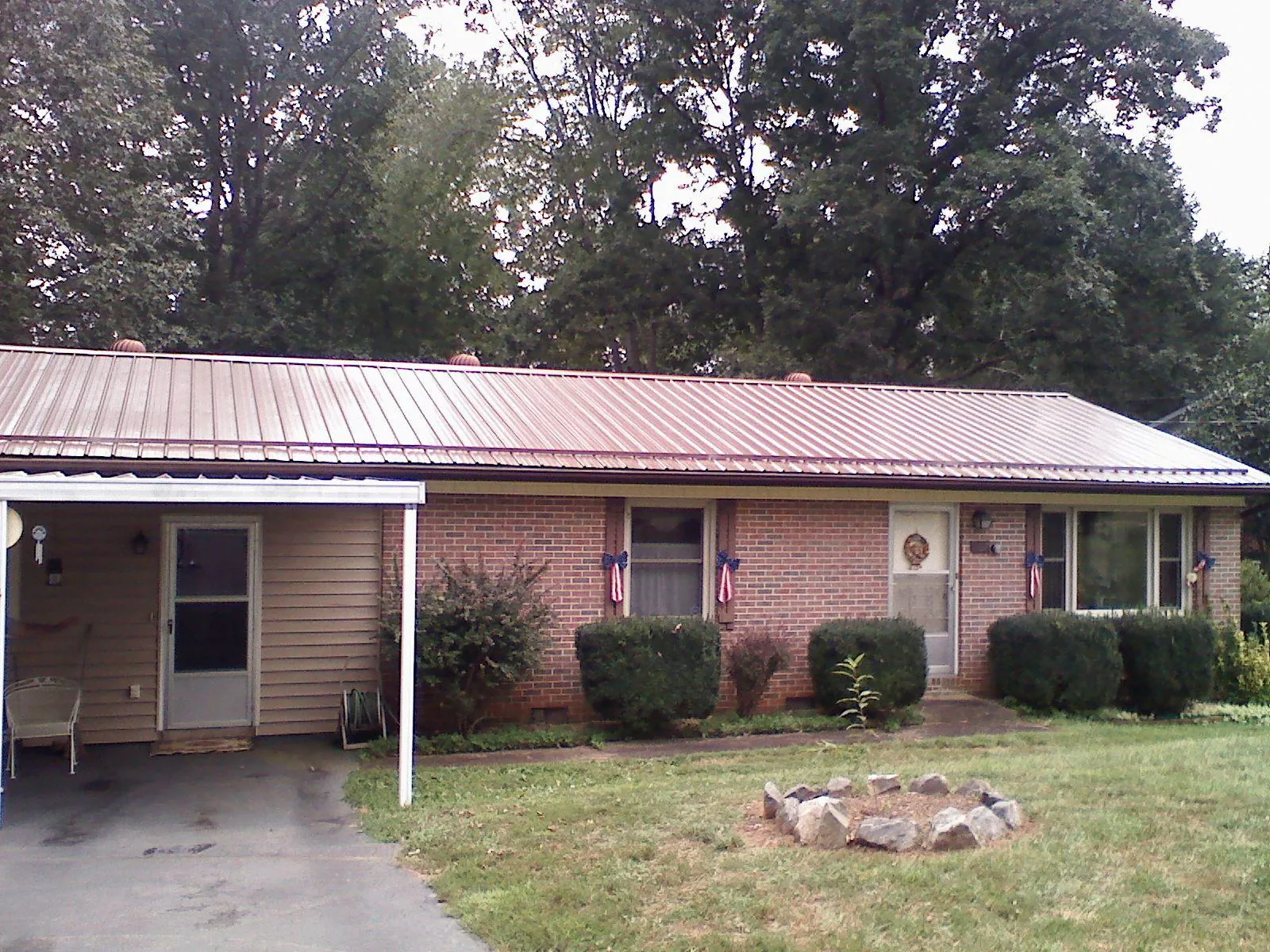 Bronze metal roof and carport on a brick ranch home — Roof Repair work by our crew in Electric City