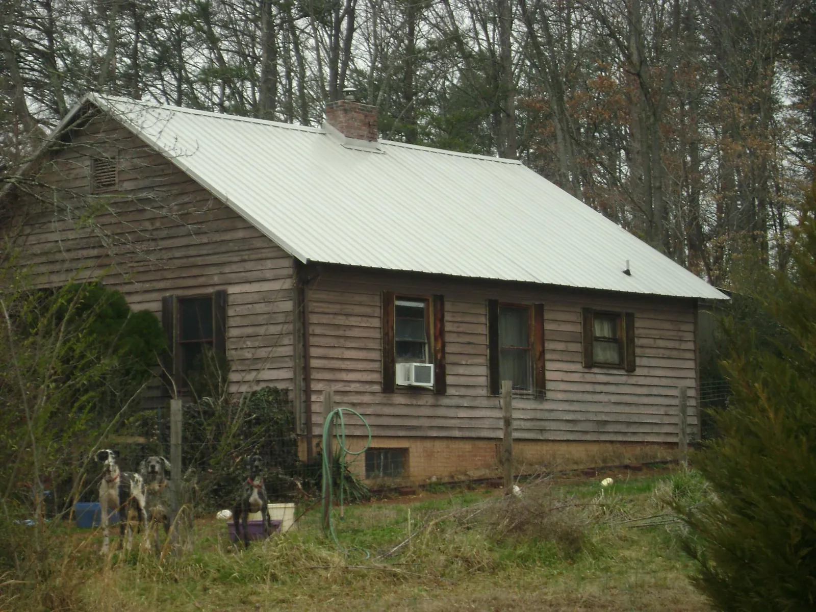 White metal roof on an old wood sided farmhouse, from a Metal Roof Installation job in Electric City